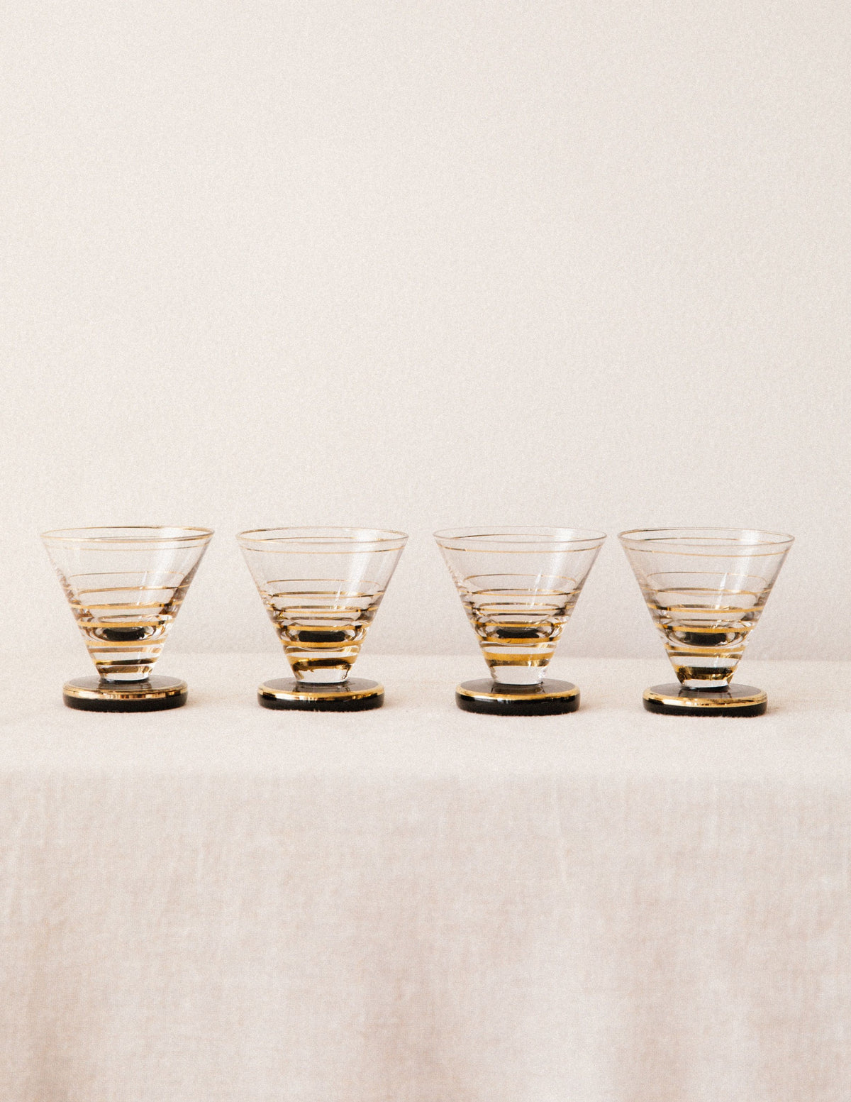 Set of four gold-rimmed cordial glasses with horizontal stripes