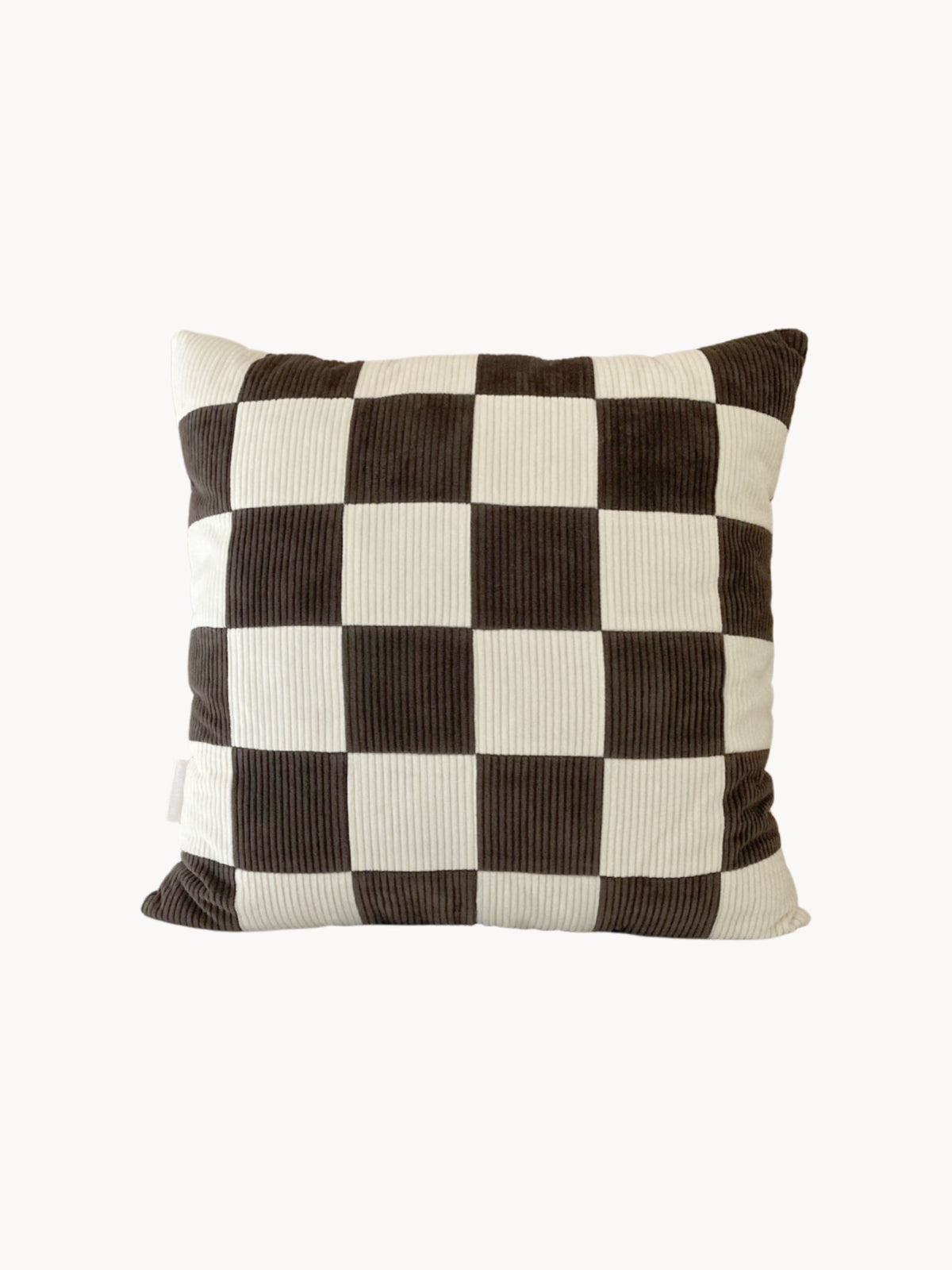 A square cushion with a checkered pattern of alternating black and white squares. The texture appears to be corduroy, giving it a ribbed appearance. This handmade UK cushion adds a classic touch to any room, and the plain white background makes it versatile for various decor styles; it's the Le Carré - Cotton Corduroy - Chalk/Espresso by AMÉLIORÉ.