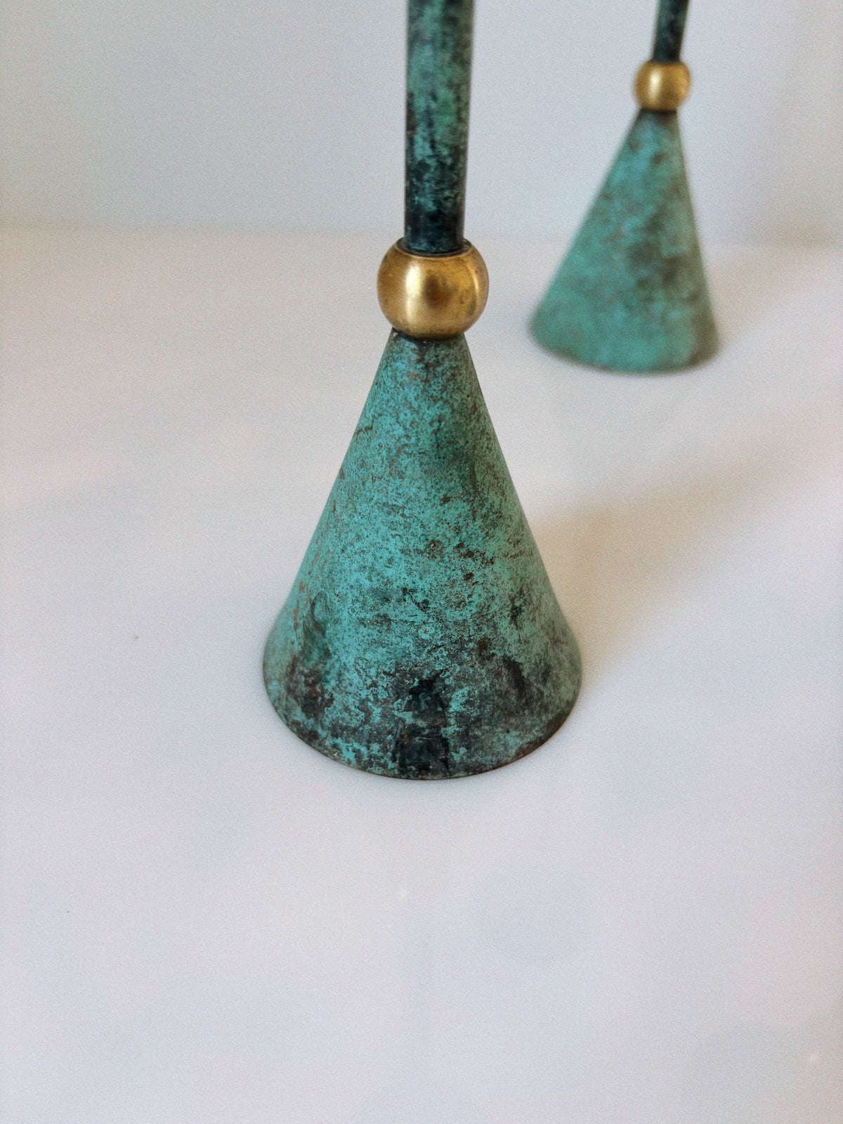 Oxidized copper candleholders with brass accents detail view
