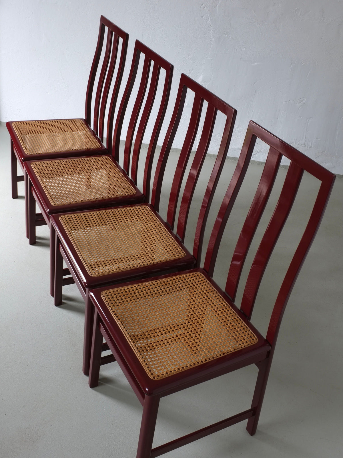 Four wine red cane seat chairs with vertical slat backs, 1970s