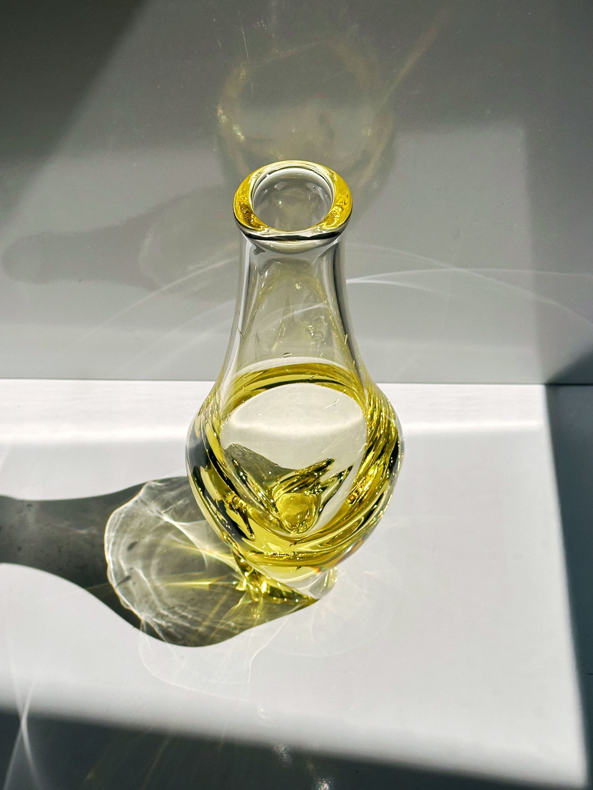 Bohemian citrine glass vase with twisted form casting golden shadows