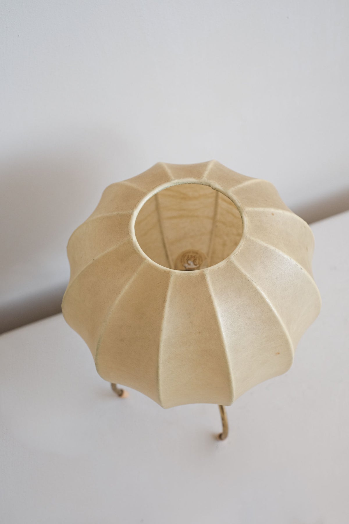 Cocoon table lamp showing fluted wood shade and brass legs detail