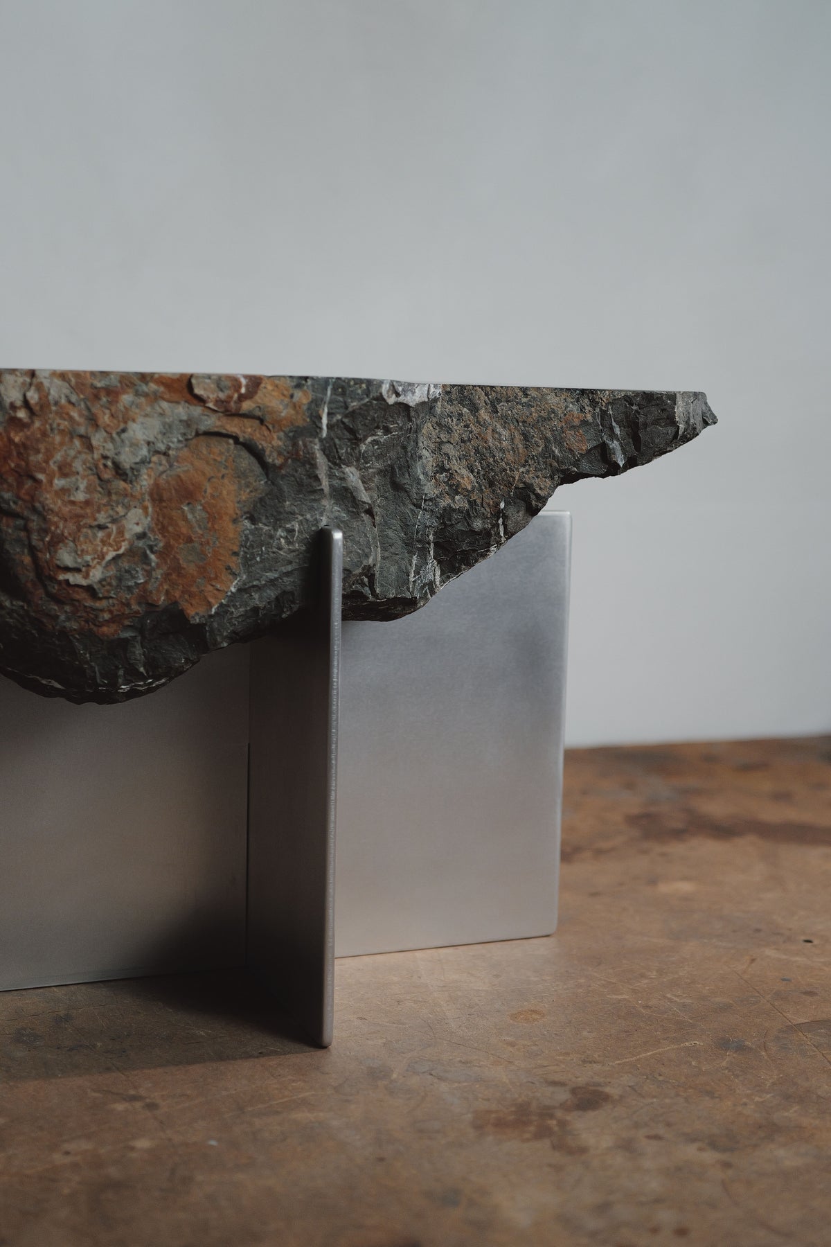 Large side table with raw stone slab top on minimalist steel base
