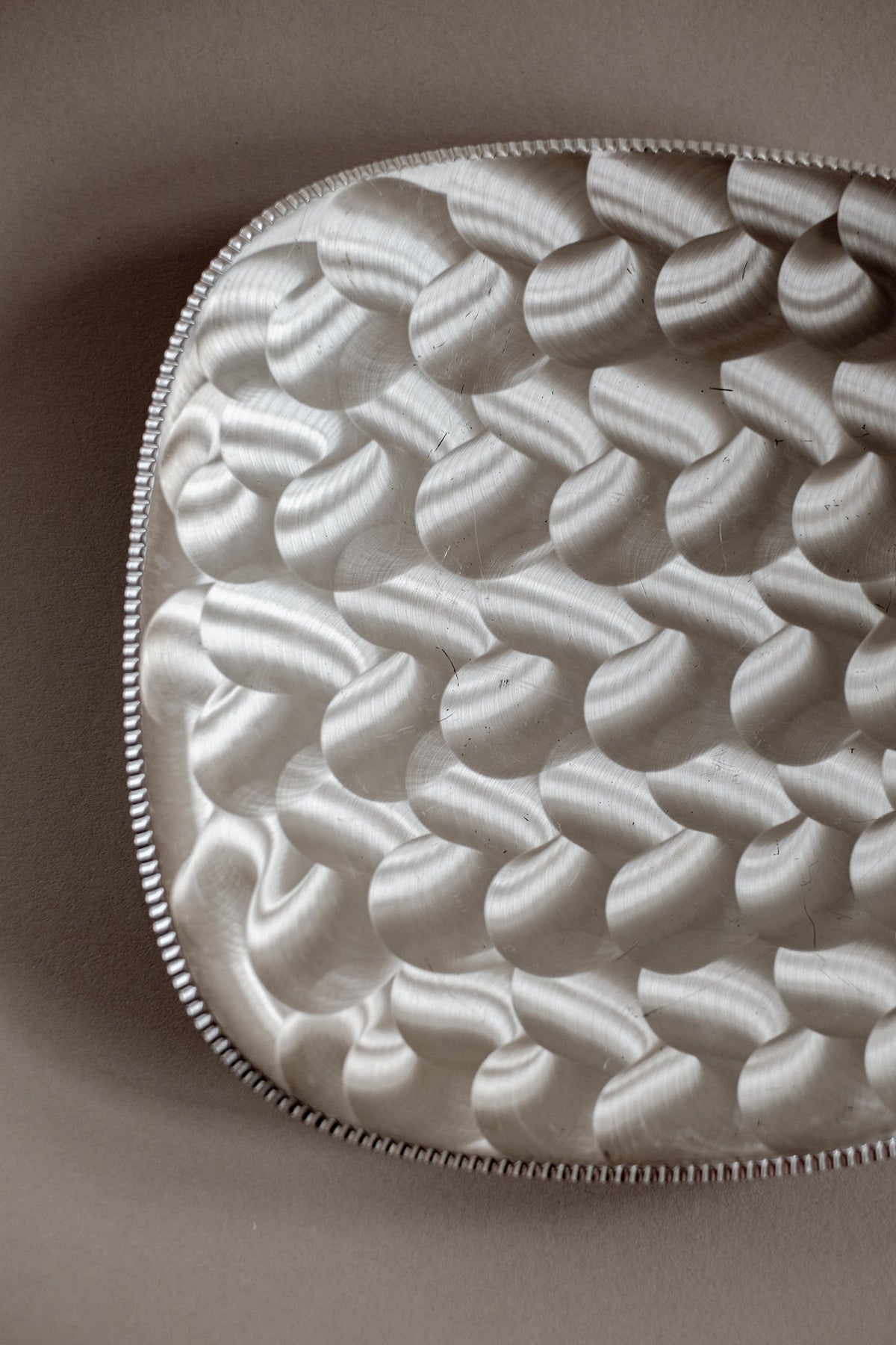 Silver-plated dish with intricate spiral relief pattern detail