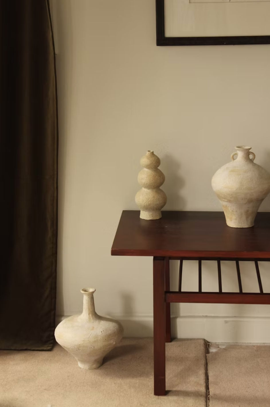Large cream ceramic amphora vessel in minimalist interior setting