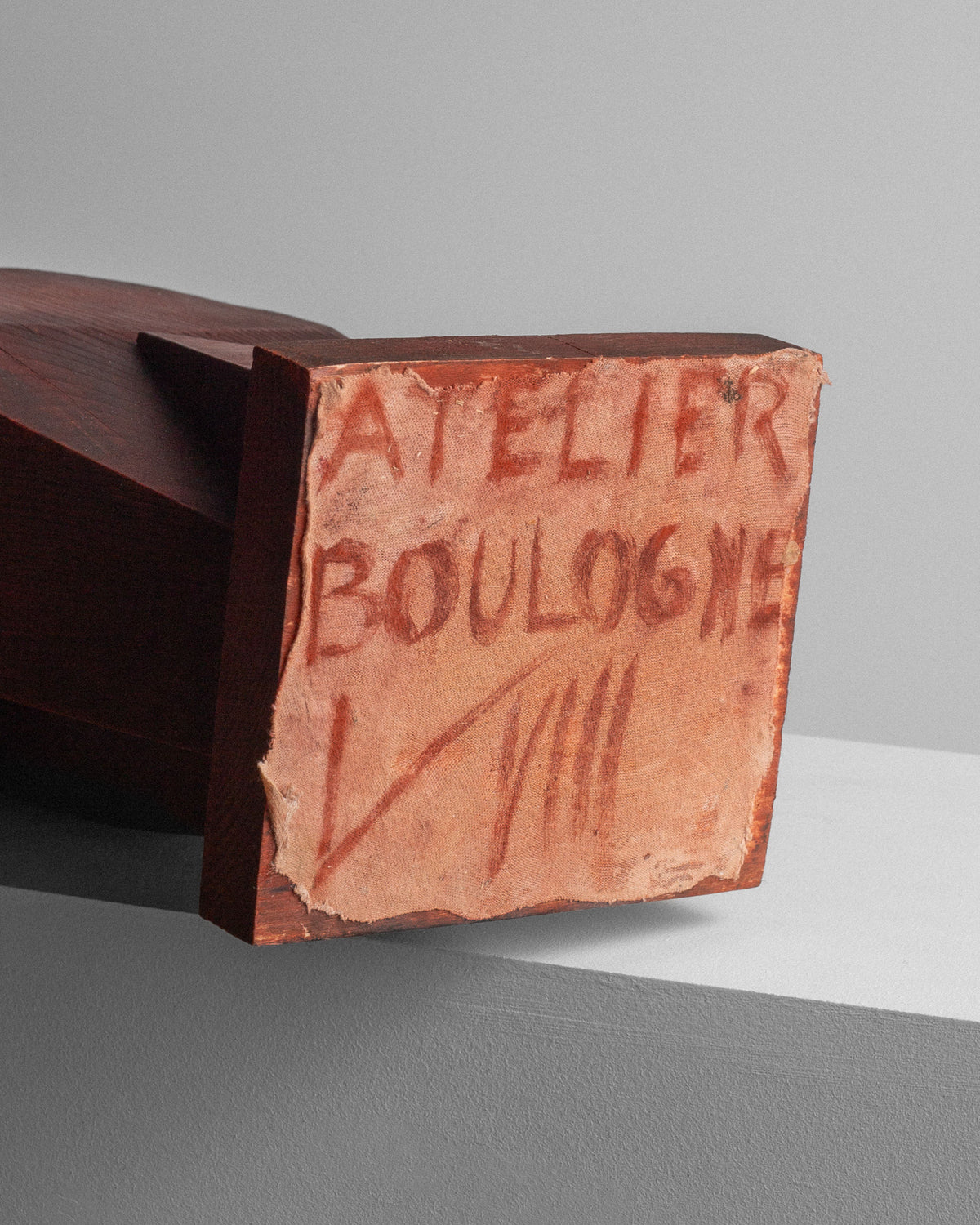 A close-up of Spigel's Vintage Cubist Sculpture II by Atelier Boulogne showcases its geometric, abstract design. It rests on a light surface, with a canvas label at the base reading "ATELIER BOULOGNE" in red handwritten letters against gray.