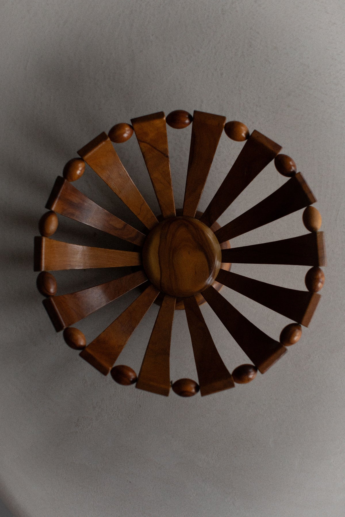 The Out For Lunch 1950's Wooden Bowl features natural grain, wide slats, and oval rim accents—ideal for rustic decor on any smooth, light-colored surface.