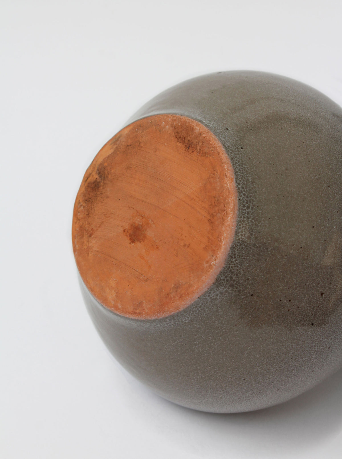 Interior view showing orange-glazed ceramic base of grey mid-century jug