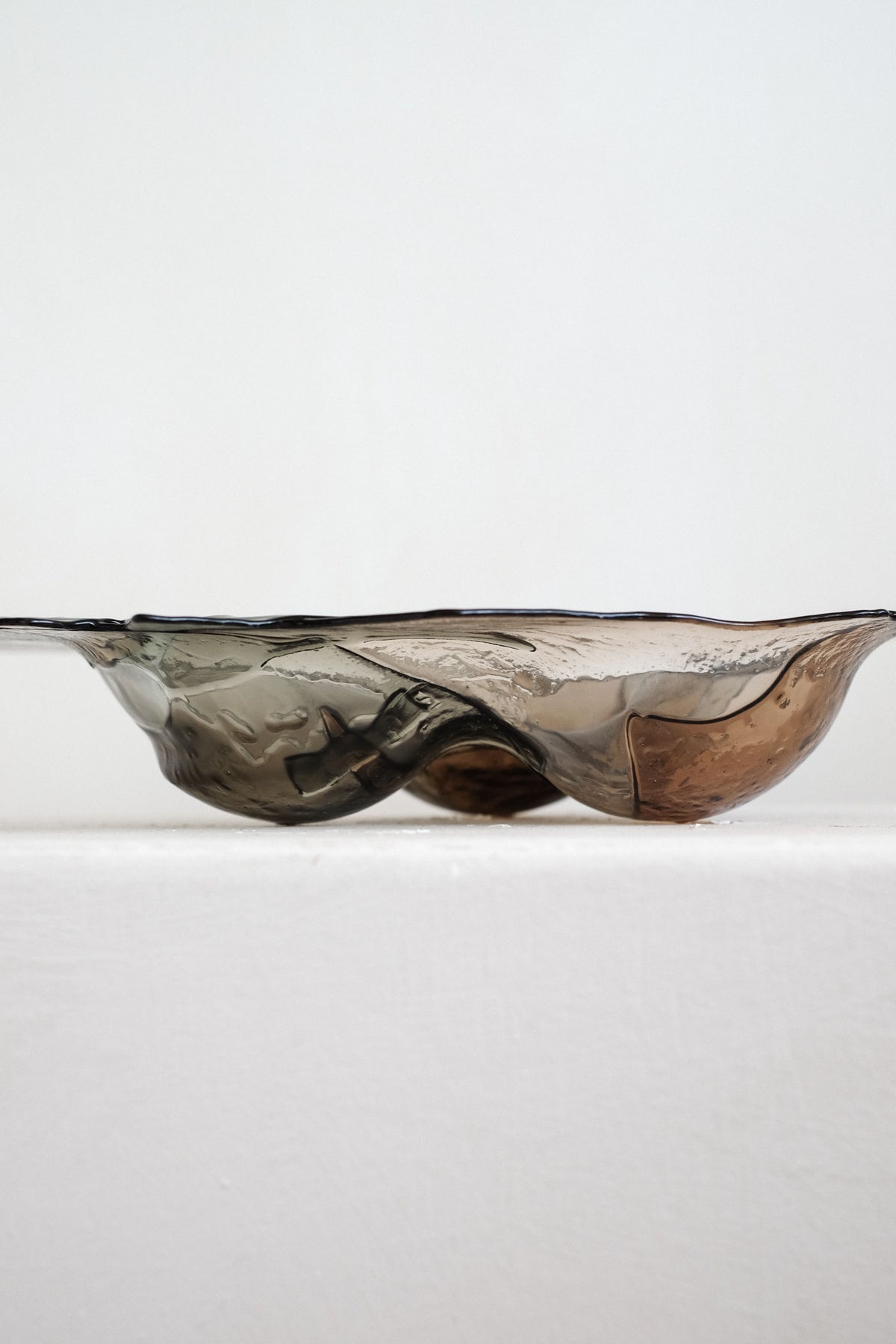 Handmade glass bowl with flowing organic curves in amber tones