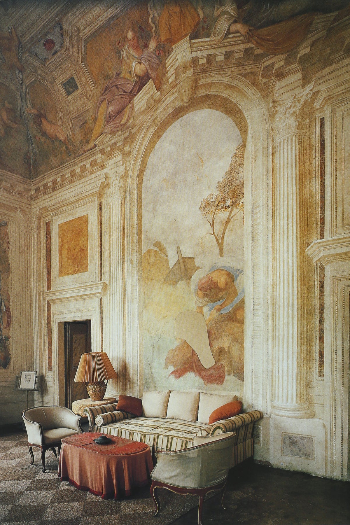 Classical interior with ornate frescoed walls and striped sofa
