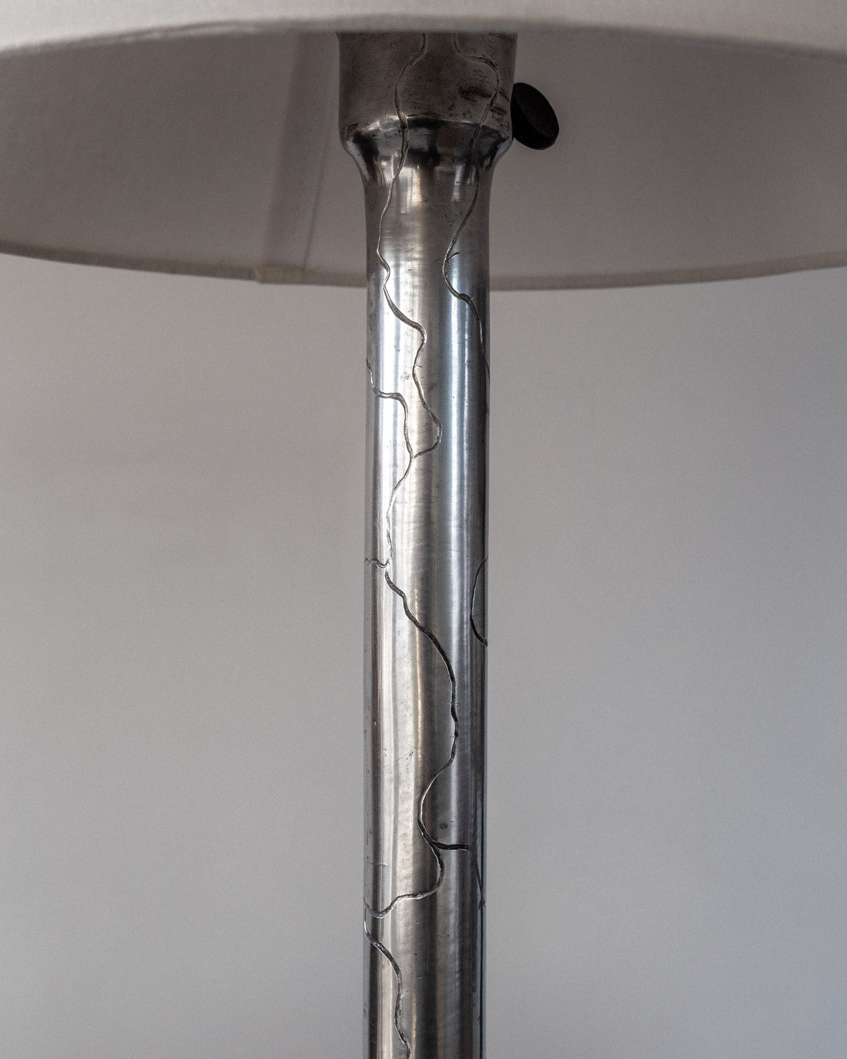 Close-up of the Spigel Art Deco Pewter Lamp, 1920s Sweden, showcasing a cracked design. A white lampshade is partially visible at the top, with the background in soft focus.