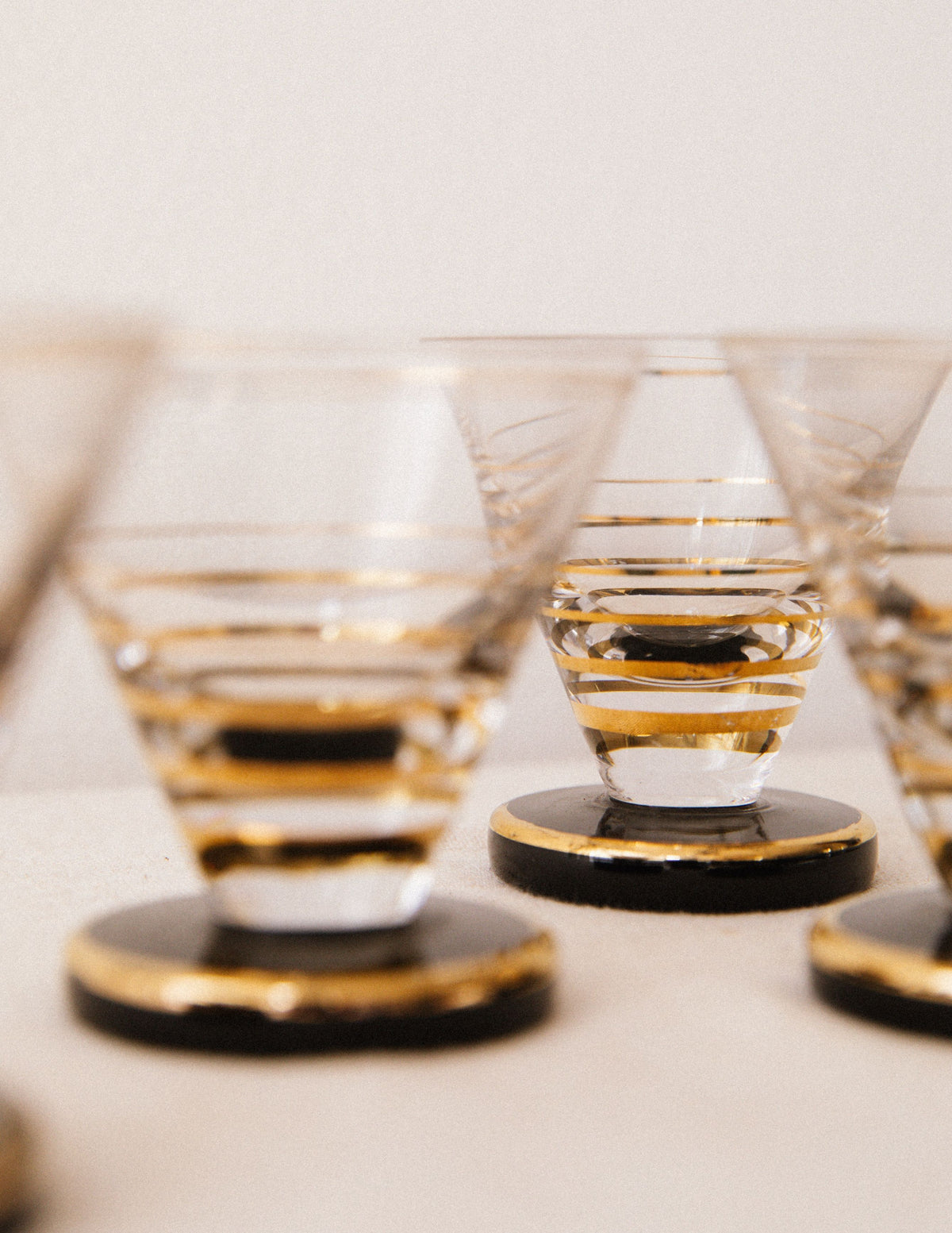 Set of elegant cordial glasses with gold striping on black bases