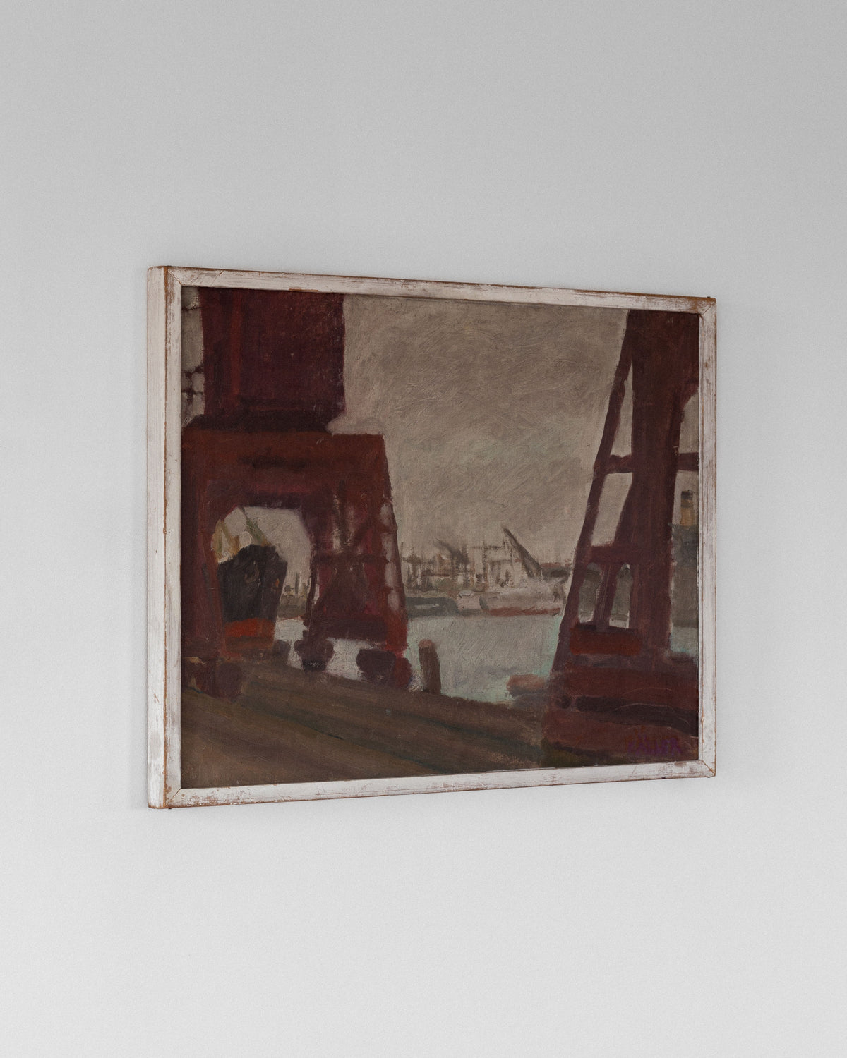 A Vintage Oil Painting by Axel Käller from the 1960s, offered by Spigel, hangs on a white wall. It depicts an industrial harbor scene with red structures and cranes against water and distant buildings under a cloudy sky, framed simply in white.