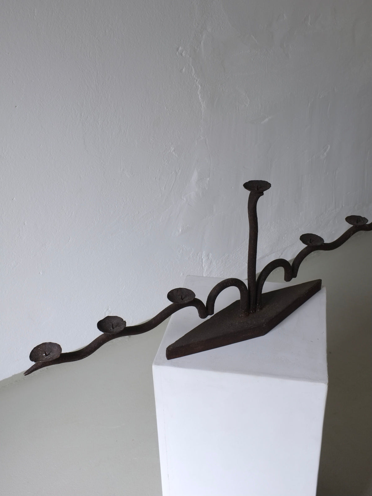 Large brutalist wrought iron candelabra detail view on white shelf