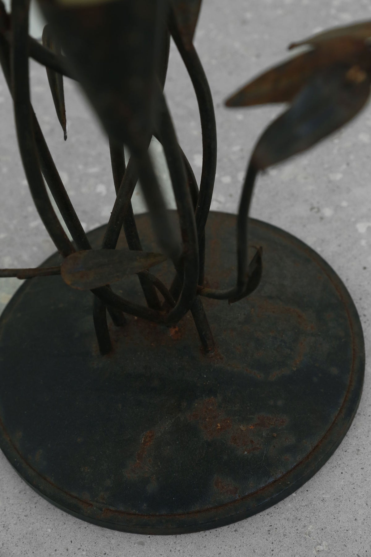 Iron candelabra sculpture base detail showing curved metal stems
