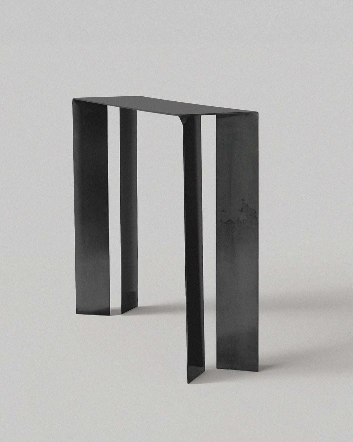 Minimalist black steel console table showing architectural side profile