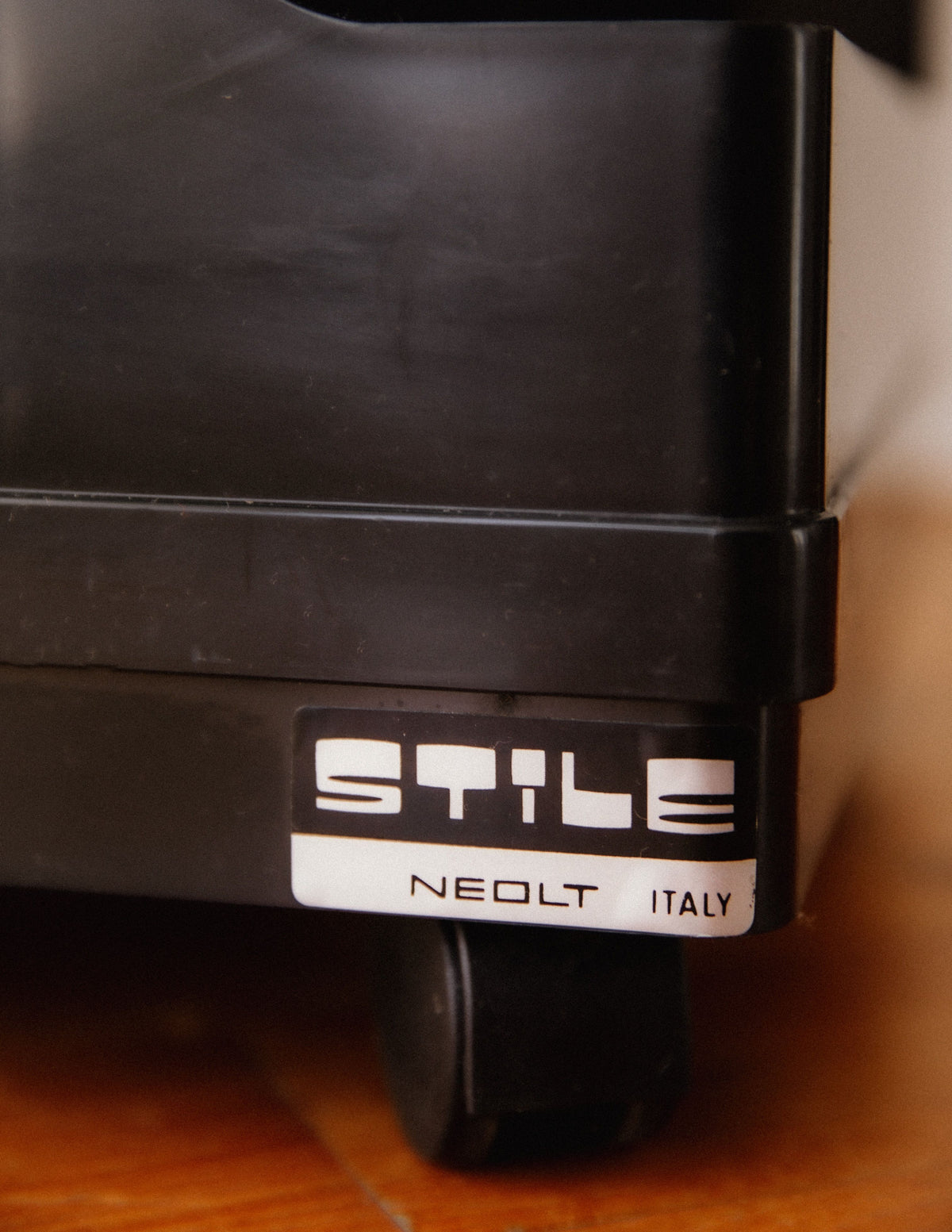 Close-up of Stile Neolt brand label on black storage trolley