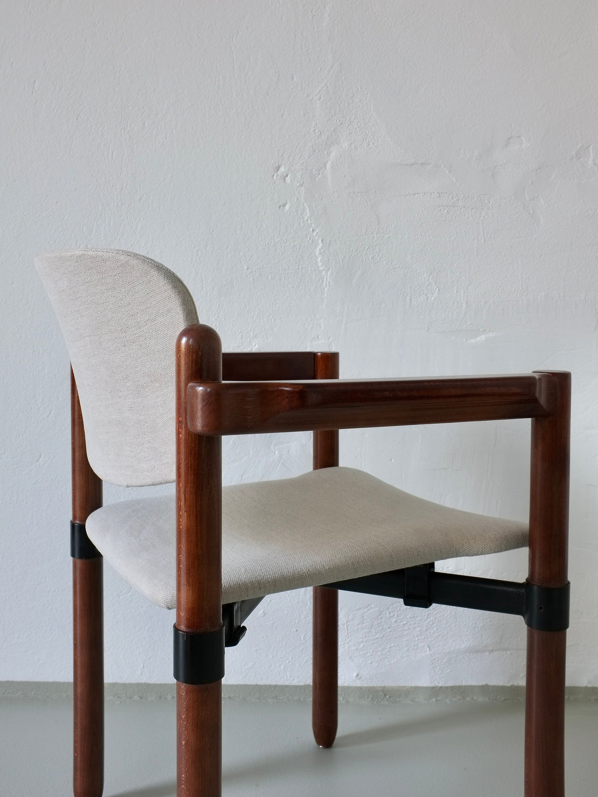 The Veter Vintage Fröscher Sitform-inspired set of 4 armchairs combines polished wooden frames with cylindrical legs and a beige fabric seat and backrest, echoing 1970s design against a plain, light-colored wall.