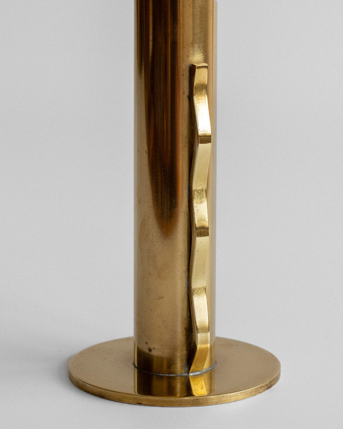 Close-up detail of brass vase base showing golden finish