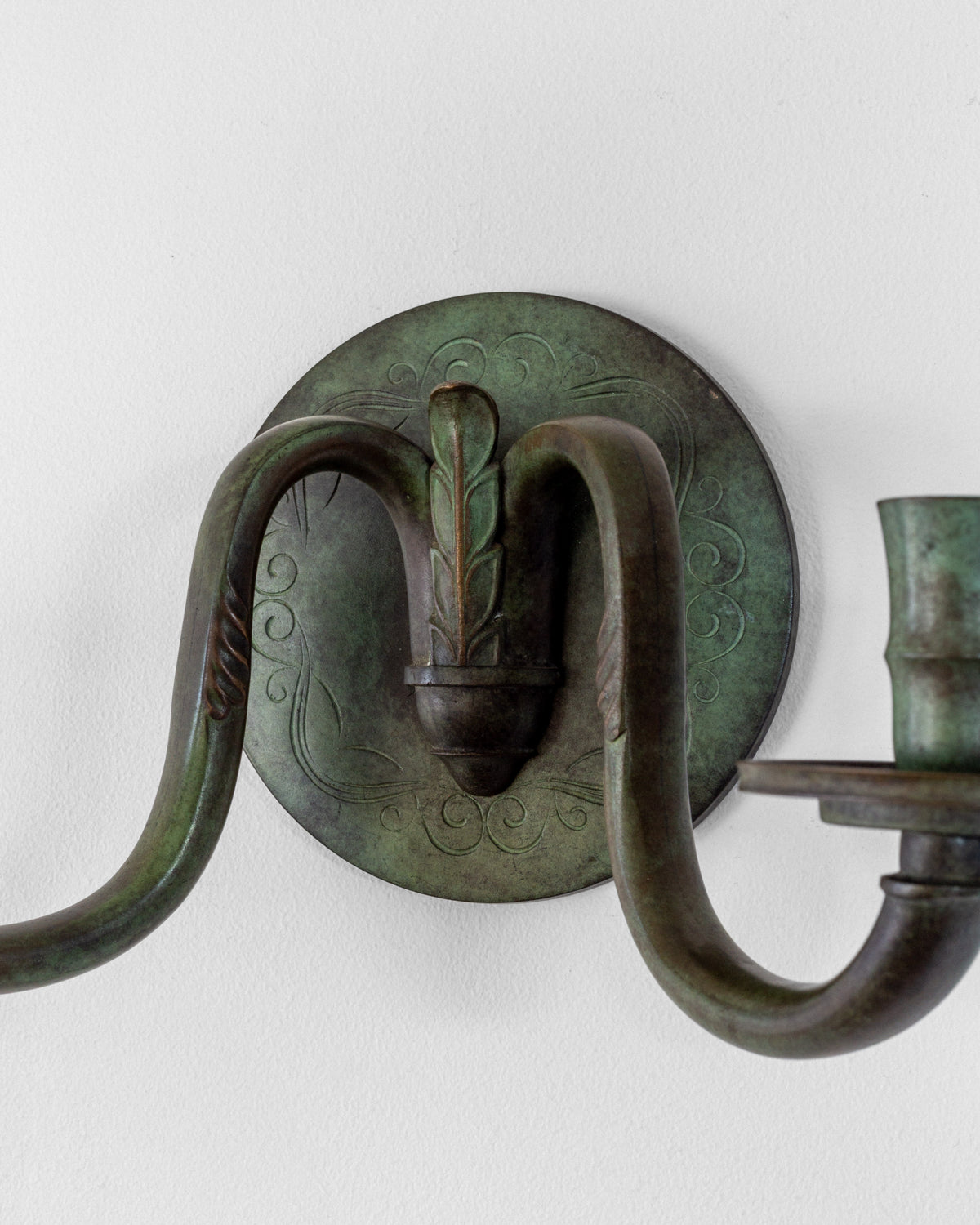 Art Deco bronze wall sconce with ornate curved arms detail