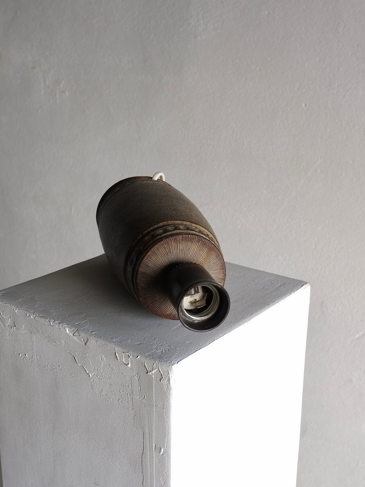 Detail view of mid-century stoneware lamp showing textured base
