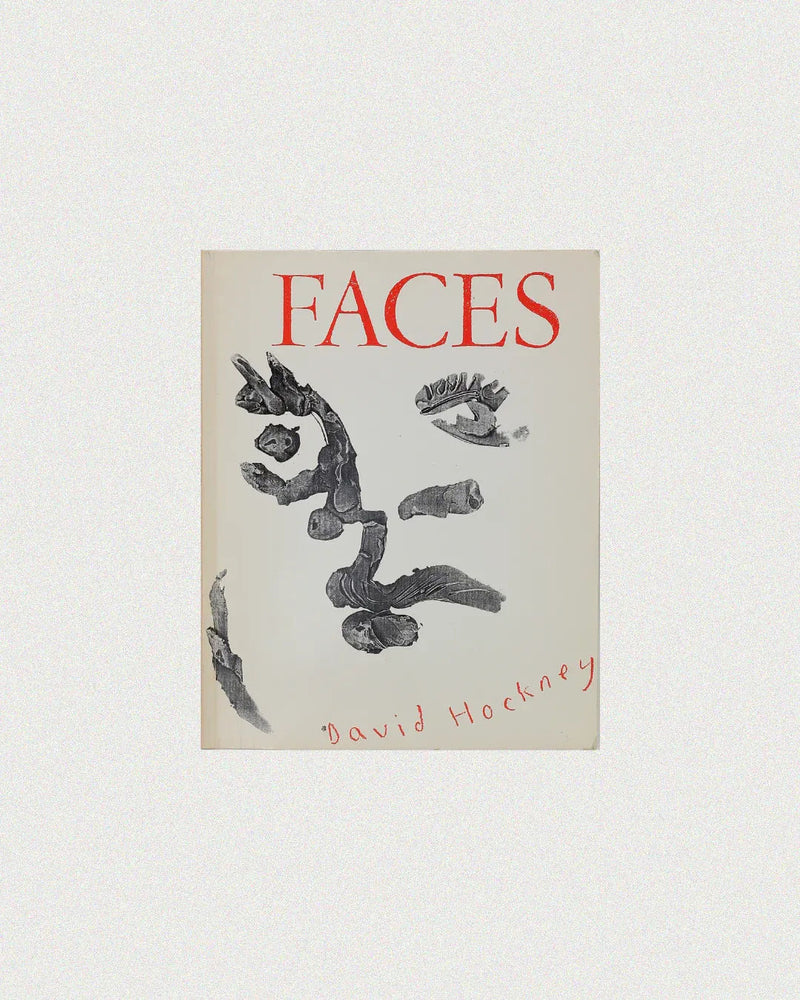 The cover of "Faces by David Hockney" from Boga Avante Shop features abstract black brushstrokes creating a face on a white background, with Hockney's handwritten name in red at the bottom, perfectly capturing his unique artistic style.