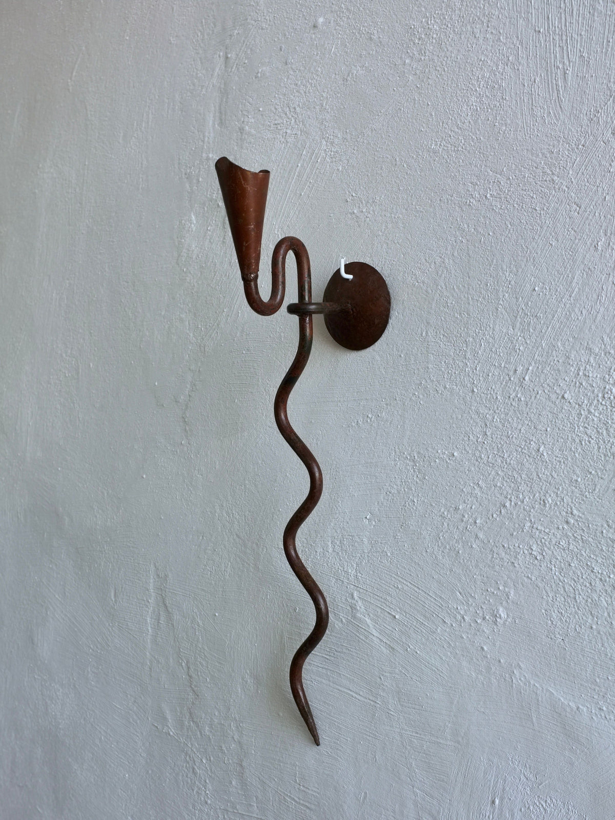 Wrought iron wall sconce with twisted arm and conical candle holder