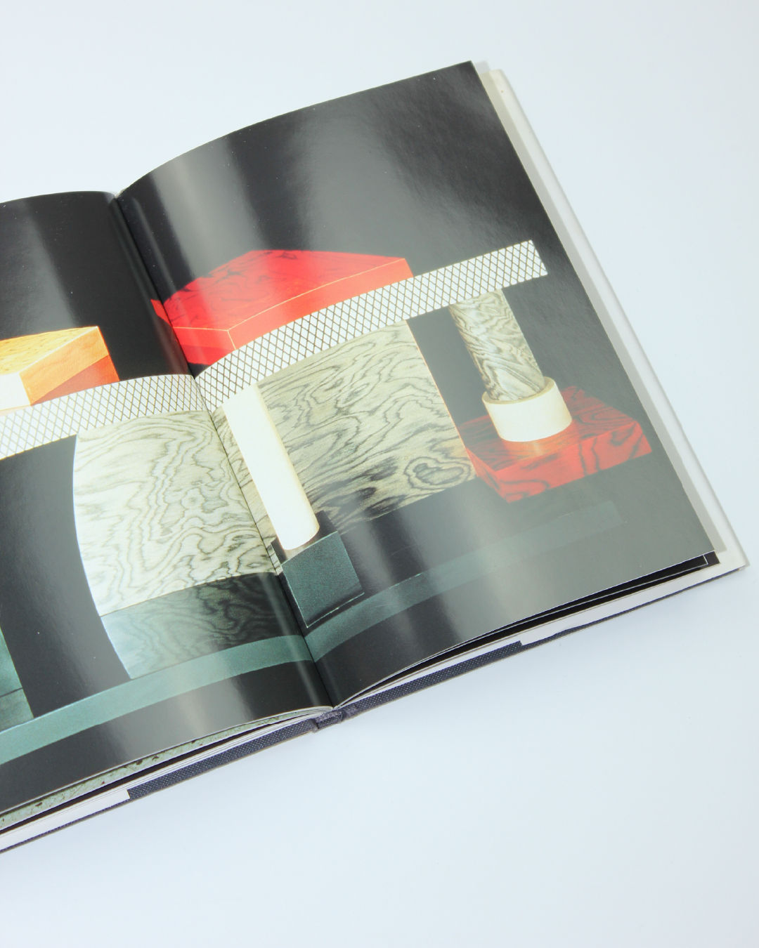 Memphis design book open showing geometric wood and metal objects