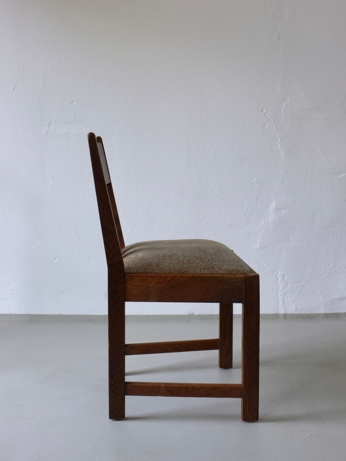 Side profile view of Arts & Crafts oak dining chair with upholstered seat