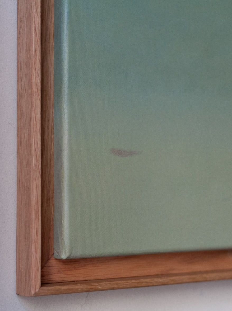 Close-up image of a framed piece of art or canvas. The frame is hand-waxed oak and the canvas appears to be painted in shades of green. There is a small smudge or mark visible on the canvas near the bottom edge, showcasing the artist's artistic prowess. The artwork is "Untitled, painting, 2024" by Rebecca von Matérn.