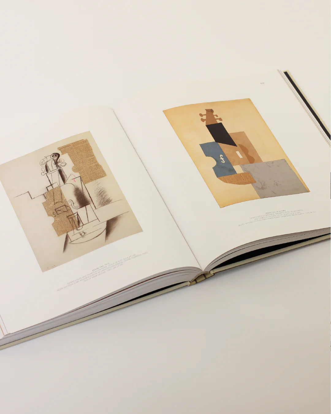 The "Cubist Picasso Book" from Boga Avante Shop, displayed open on a light surface, embodies the essence of Cubism. The left page showcases a sketch with geometric shapes that echo the style of a Picasso piece, while the right page presents a composition featuring a violin shape in muted earth tones.
