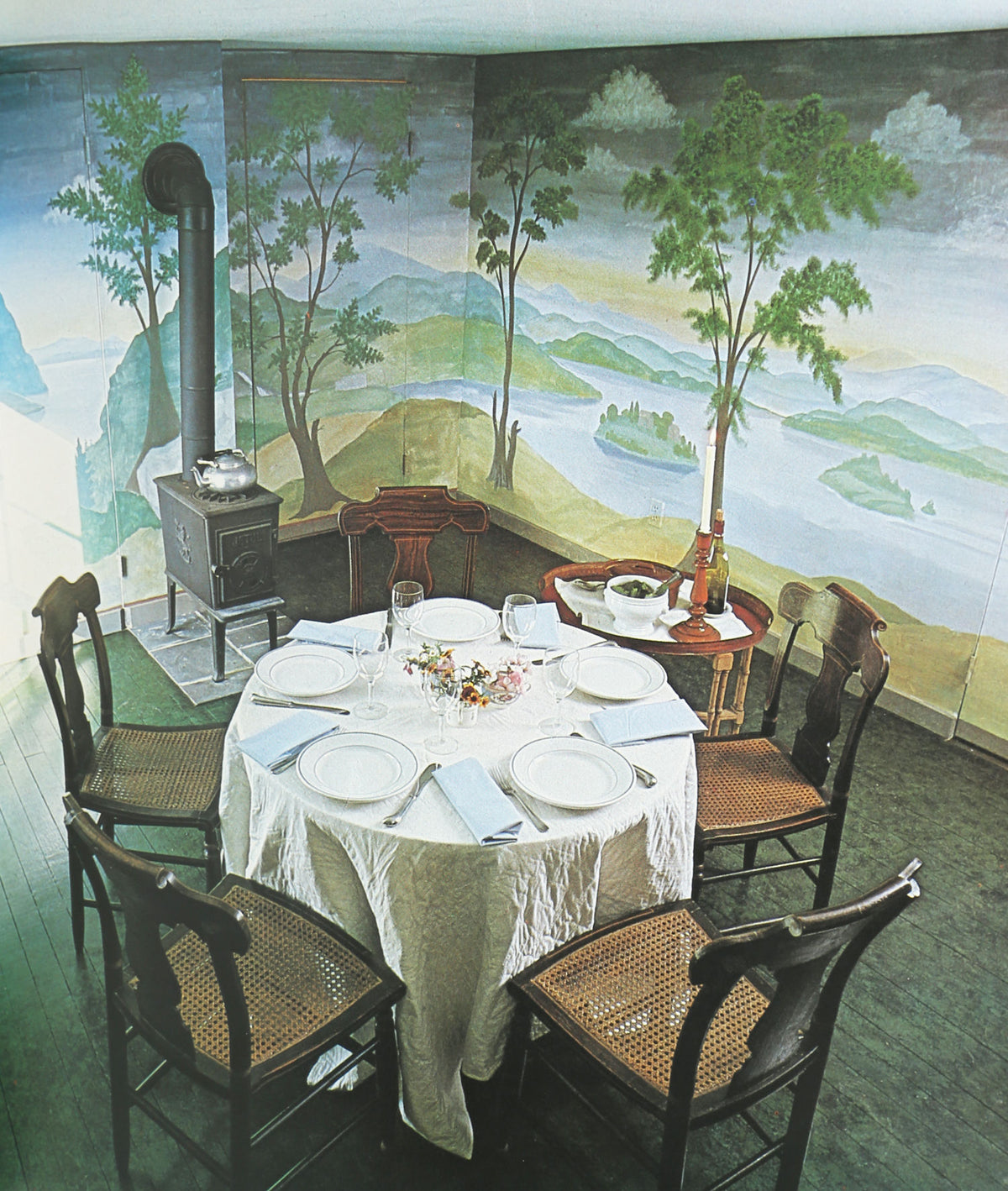 Colonial dining room interior with painted landscape mural and period furniture