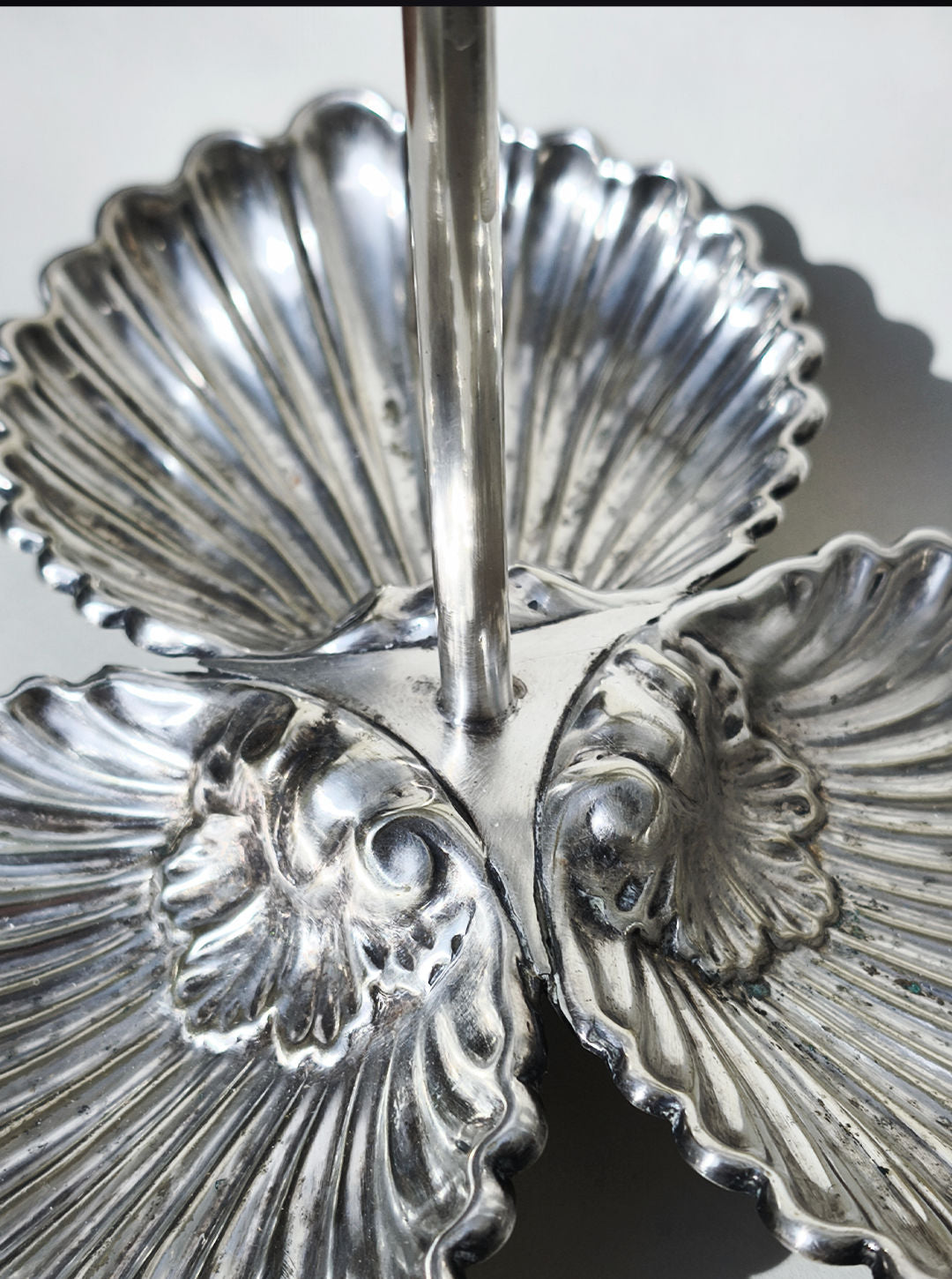 The Les Objoies Large Silver-plated Triple Tray features three shell-shaped compartments around a central handle. Its elegant design and textured finish beautifully reflect light, making it an eye-catching serving piece.
