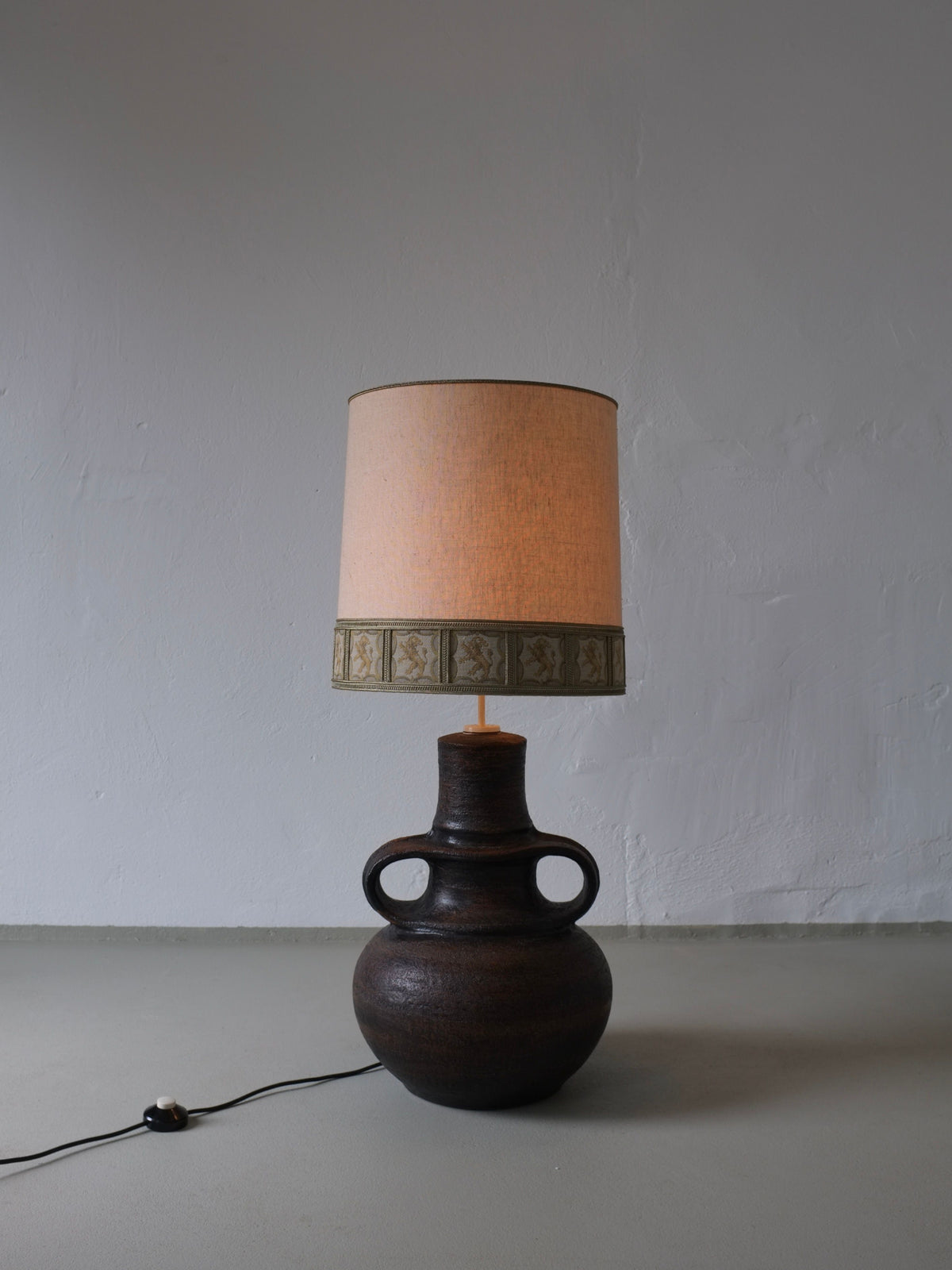 Dark brown ceramic lamp base with handles and beige shade