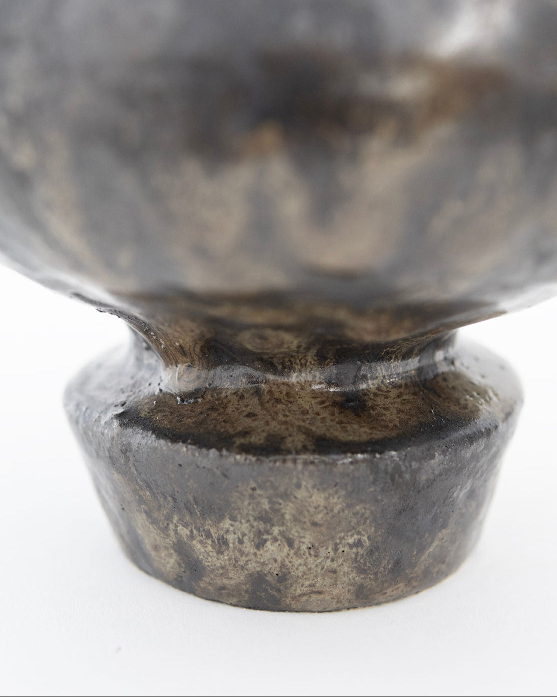 Close-up view of Kylix Obsidiana vase base with aged patina finish