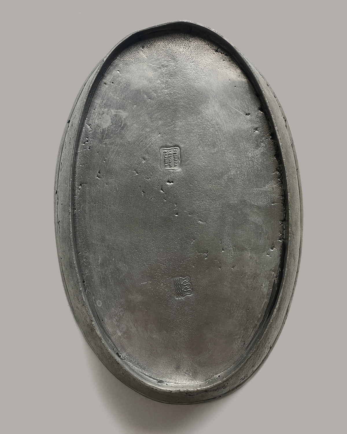 Bottom view of pewter bowl showing maker's marks and craftsmanship