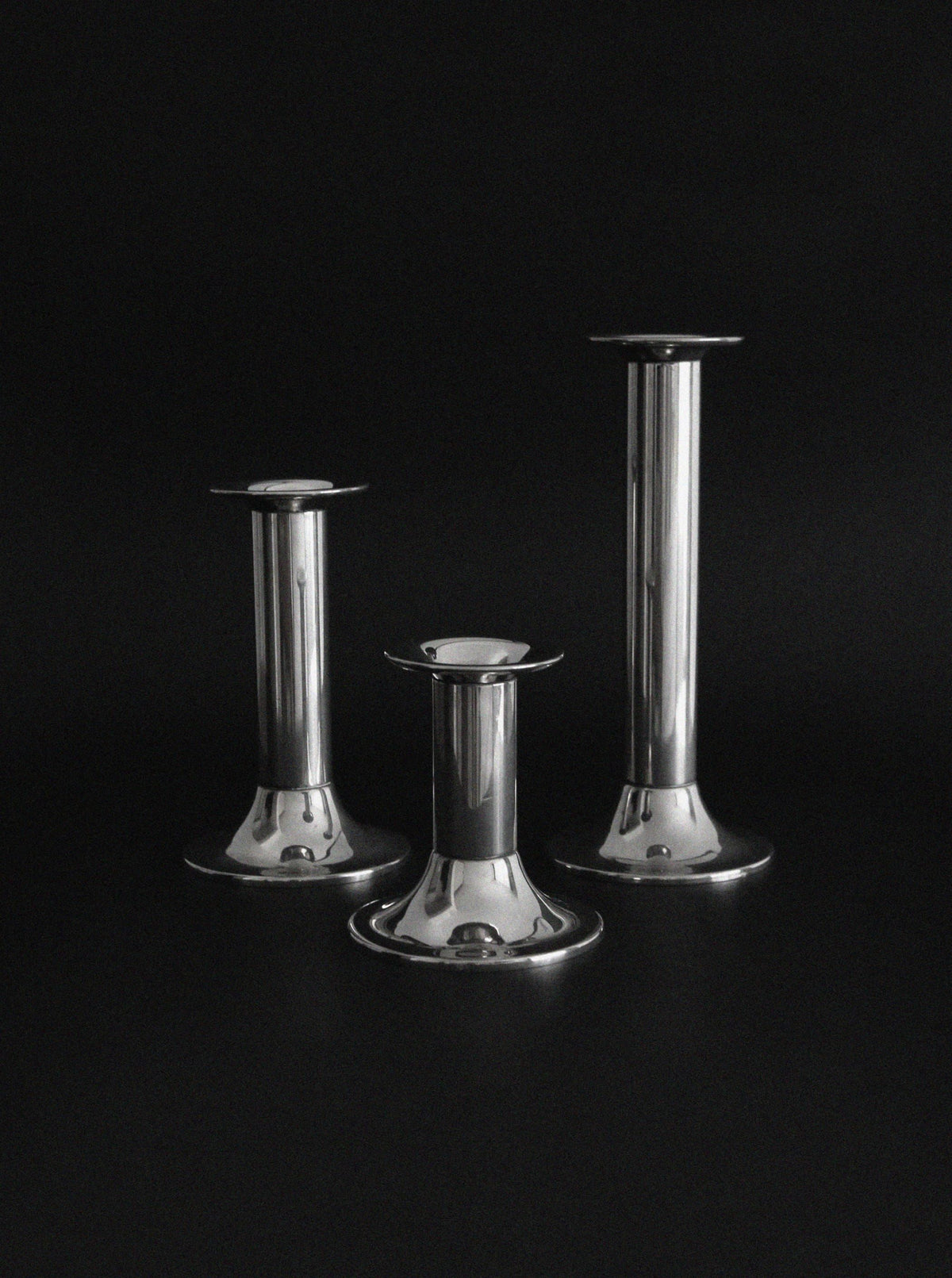 Three vintage silver plated candlesticks of varying heights