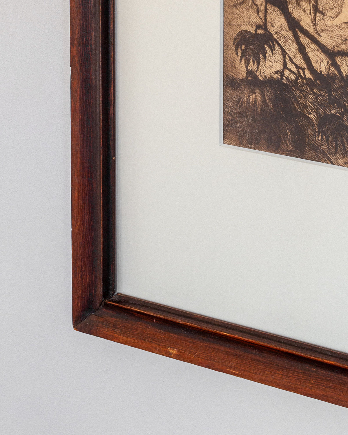 A close-up of a framed Spigel etching, "Adam & Eve" by Gaston Smidt, 1900s, displays sepia-toned natural scenery with trees in a wooden border and off-white matte frame.