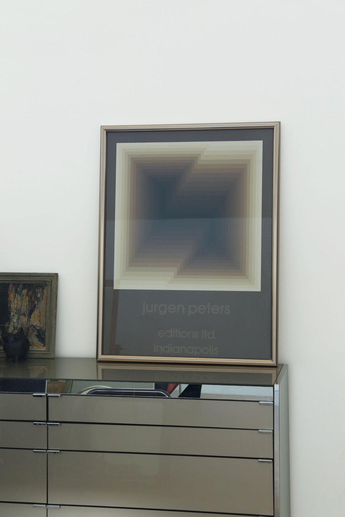 Framed Jurgen Peters abstract print displayed on modern dresser