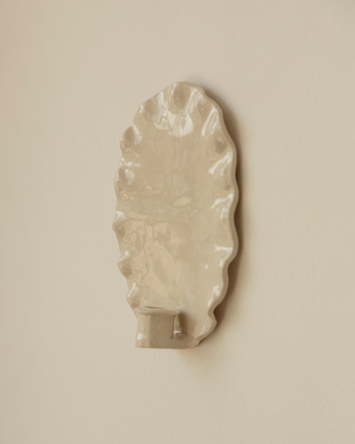 Cream ceramic oval candle sconce with leaf motif wall detail