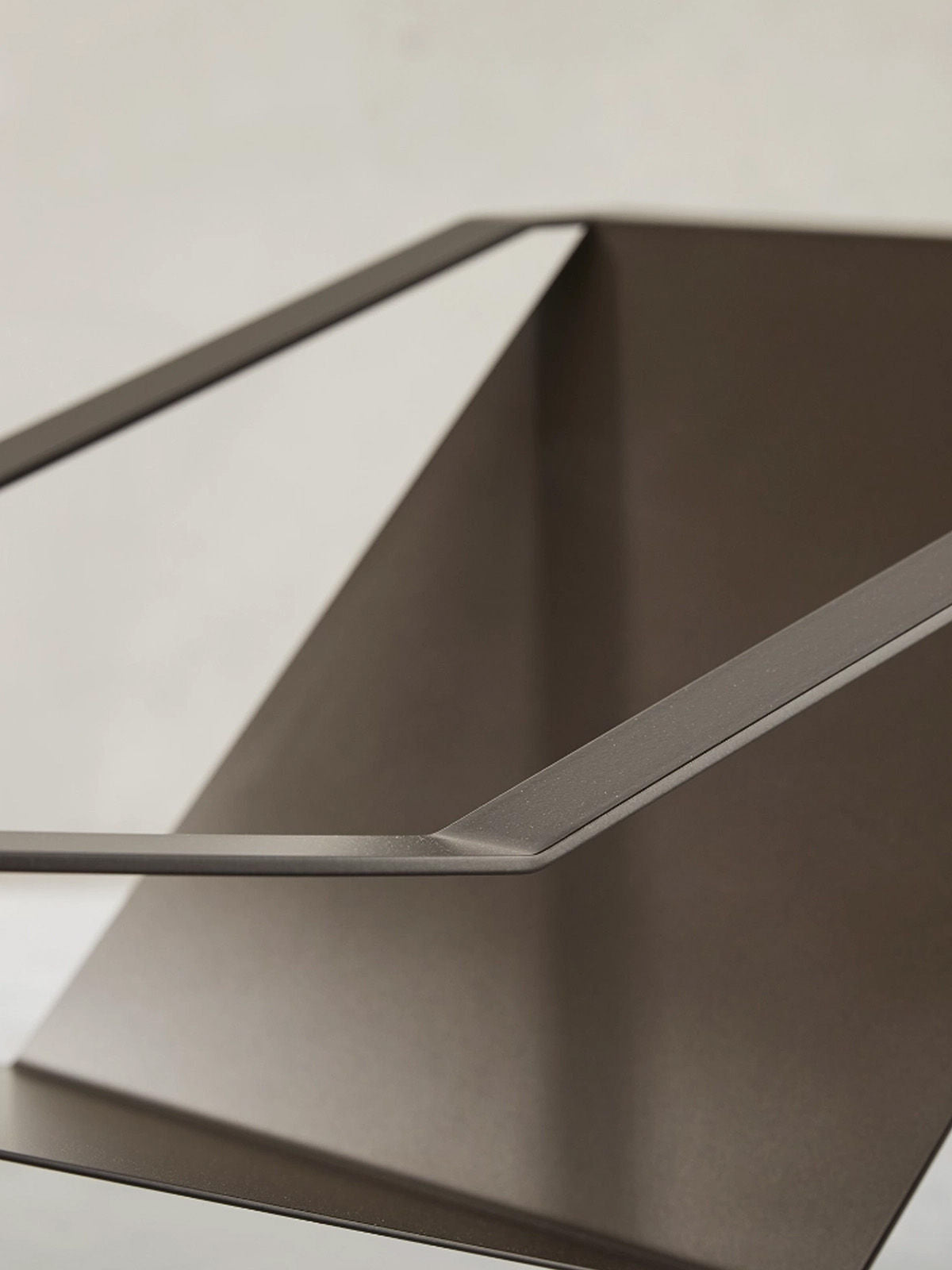 Close-up detail of Suspendu lounge chair's curved metal frame