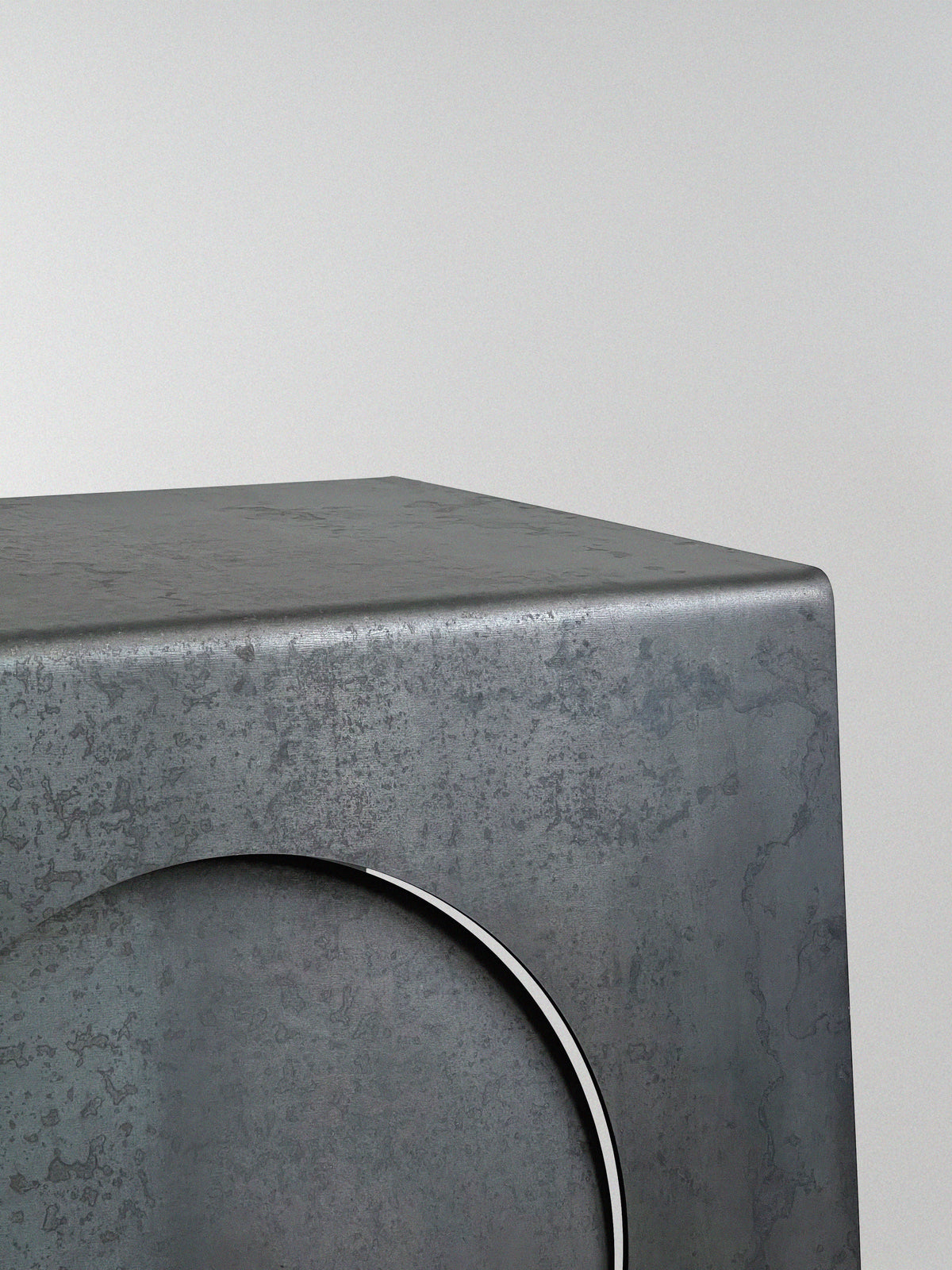 A close-up of the 'Era' Side Table by Modan, featuring a metallic, industrial design with a smooth matte finish, subtle texture, and a distinctive large circular indentation on one side highlighting its unique style.
