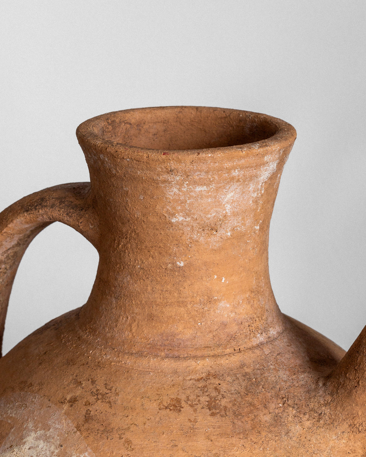 The image features an Early 20th Century European Ceramic Pitcher by Spigel, with a wide spout and side handle. This handcrafted piece has a textured surface that suggests age and use, set against a plain gray background.