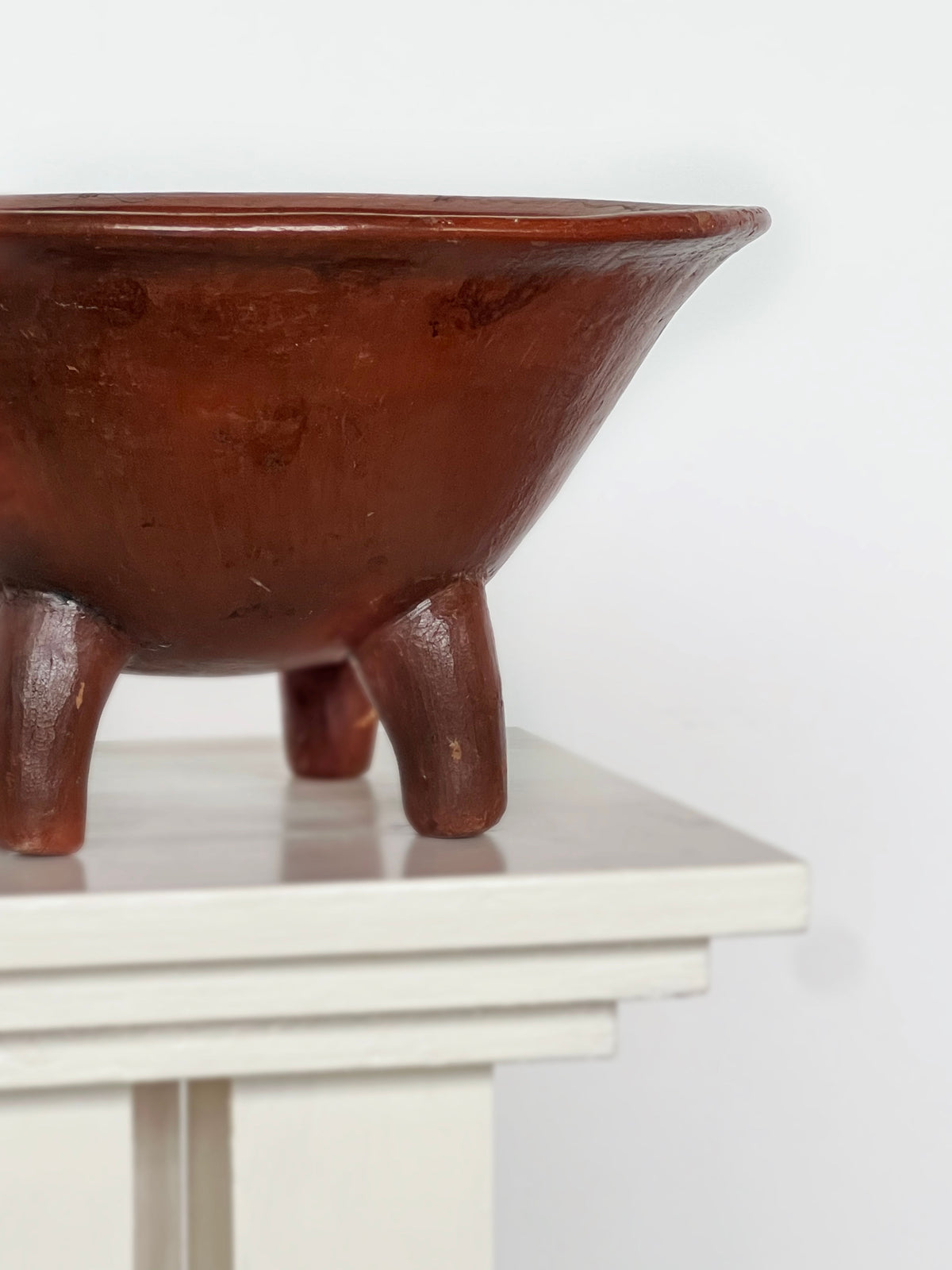 Terracotta tripod bowl detail showing curved legs and spout