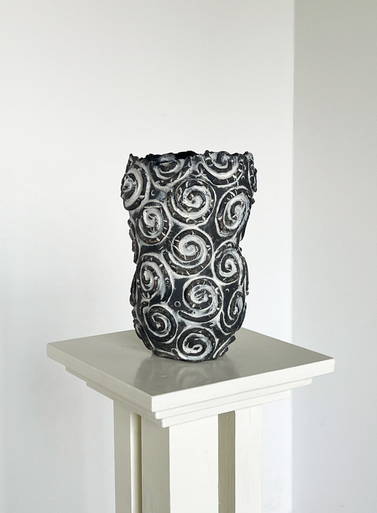 Handcrafted ceramic vase with raised spiral pattern detail
