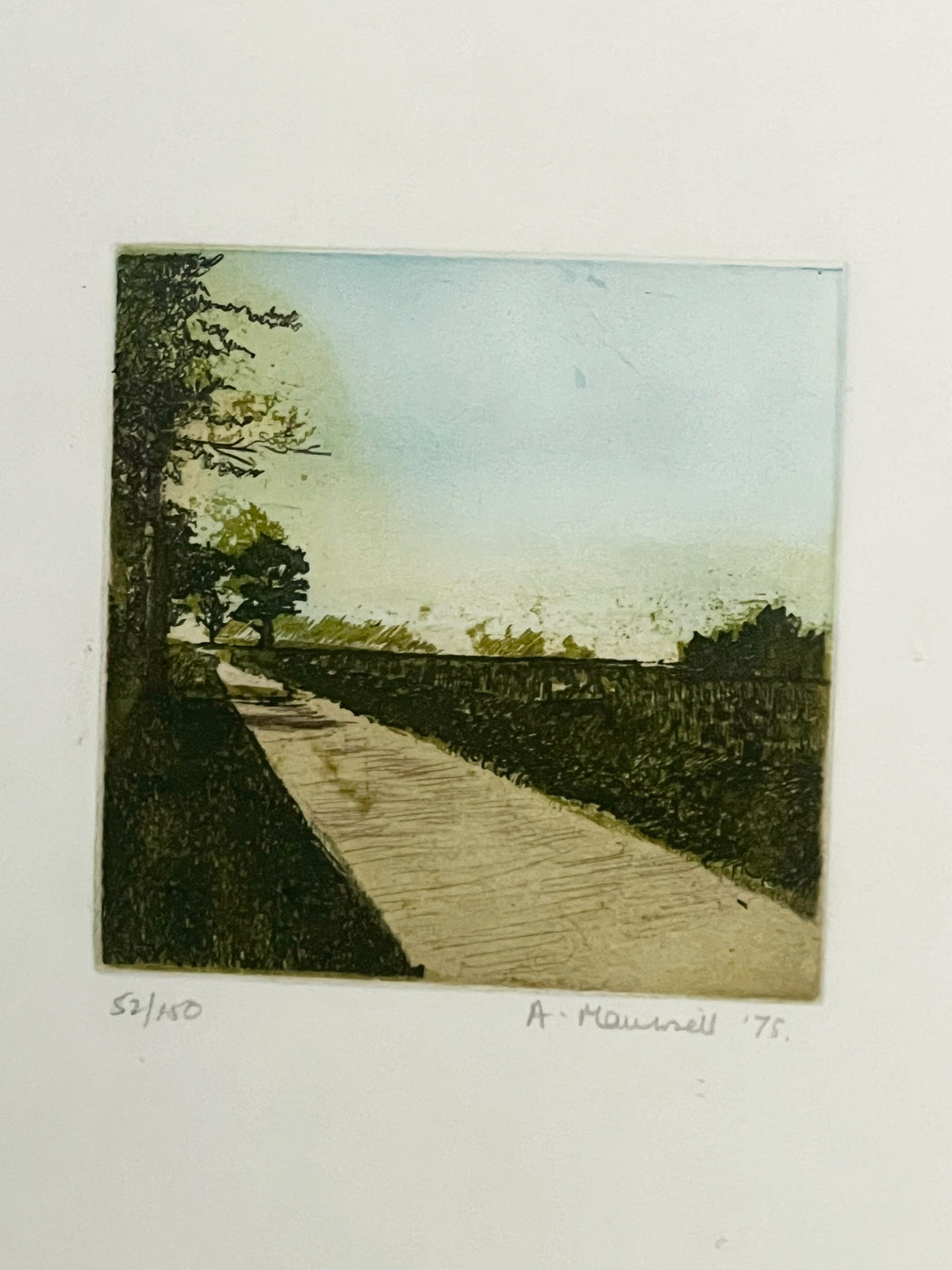 Porter Studio's Framed Landscape features a signature artwork of a path with grass and trees, under a clear blue sky, set in a chrome frame with handwritten notes beneath.