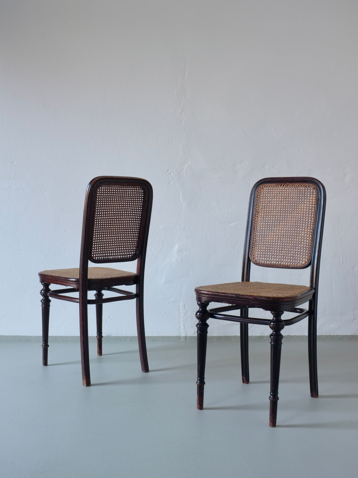 Two 1906 Thonet bentwood cane chairs with woven seats and backs