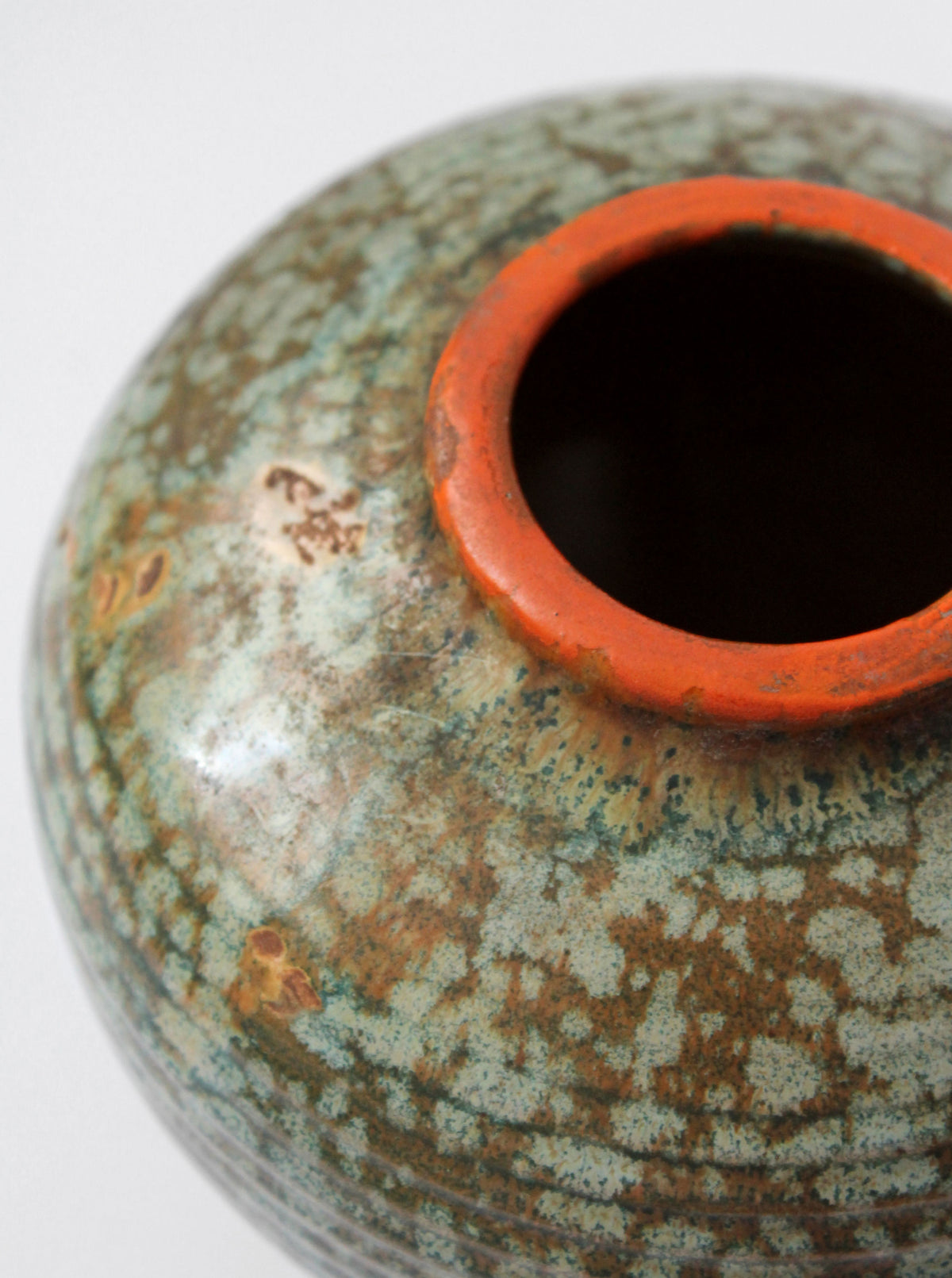 Close-up detail of vintage ceramic vase showing textured glaze and rim