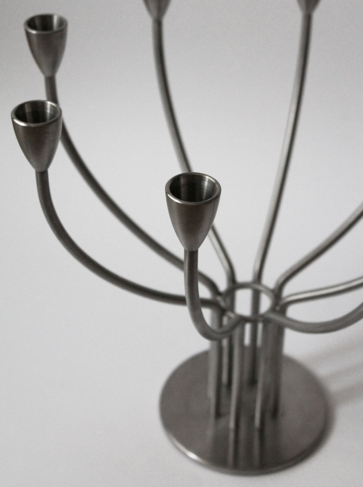 The Brushed Metal Swedish Candelholder by Vintage Stories features a sleek silver Scandinavian design with multiple curved arms for several candles, shown against a plain white background.