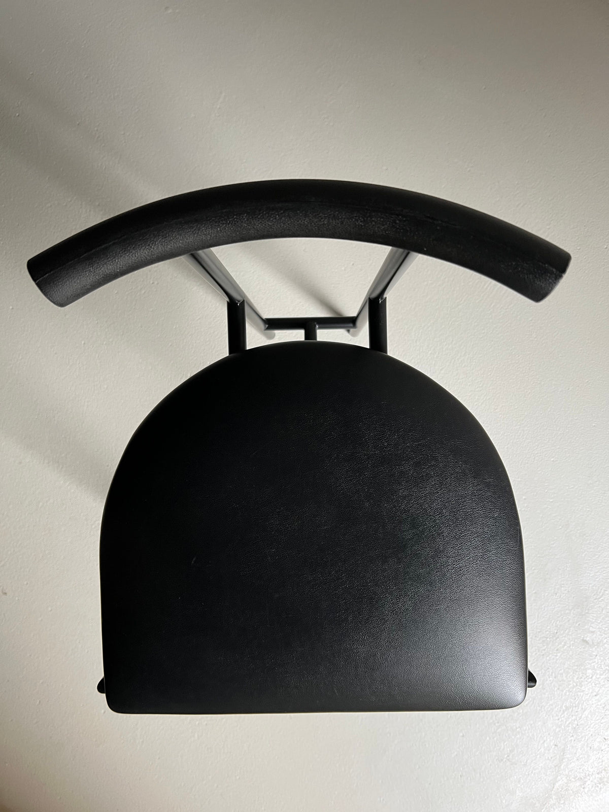 A set of 4 Postmodern "Tokyo" Chairs by Rodney Kinsman, sold under the brand name Veter Vintage, with a curved backrest and a flat seat viewed from above, set against a plain beige background. The chairs have a minimalist, modern design with sleek lines, black metal accents, and a matte finish.